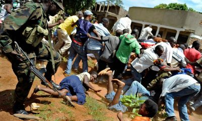 A Ugandan military UPDF officer (L) disperse supporters of Ugandan opposition leader Kizza Besigye who had gathered in large numbers to welcome him back to Kampala from Nairobi on May 12, 2011 where he had gone to seek medical treatment for injuries sustained after he was attacked by state security personnel during an opposition demonstration. Ugandan President Yoweri Museveni vowed to stamp out "disrupting schemes" on May 12 as he was sworn in for a fourth term while masses of opposition supporters welcomed home his rival, Kizza Besigye. AFP PHOTO/Tony KARUMBA (Photo credit should read TONY KARUMBA/AFP/Getty Images)